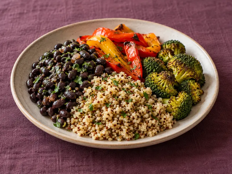 Black beans, quinoa and vegetables on a stoneware plate.